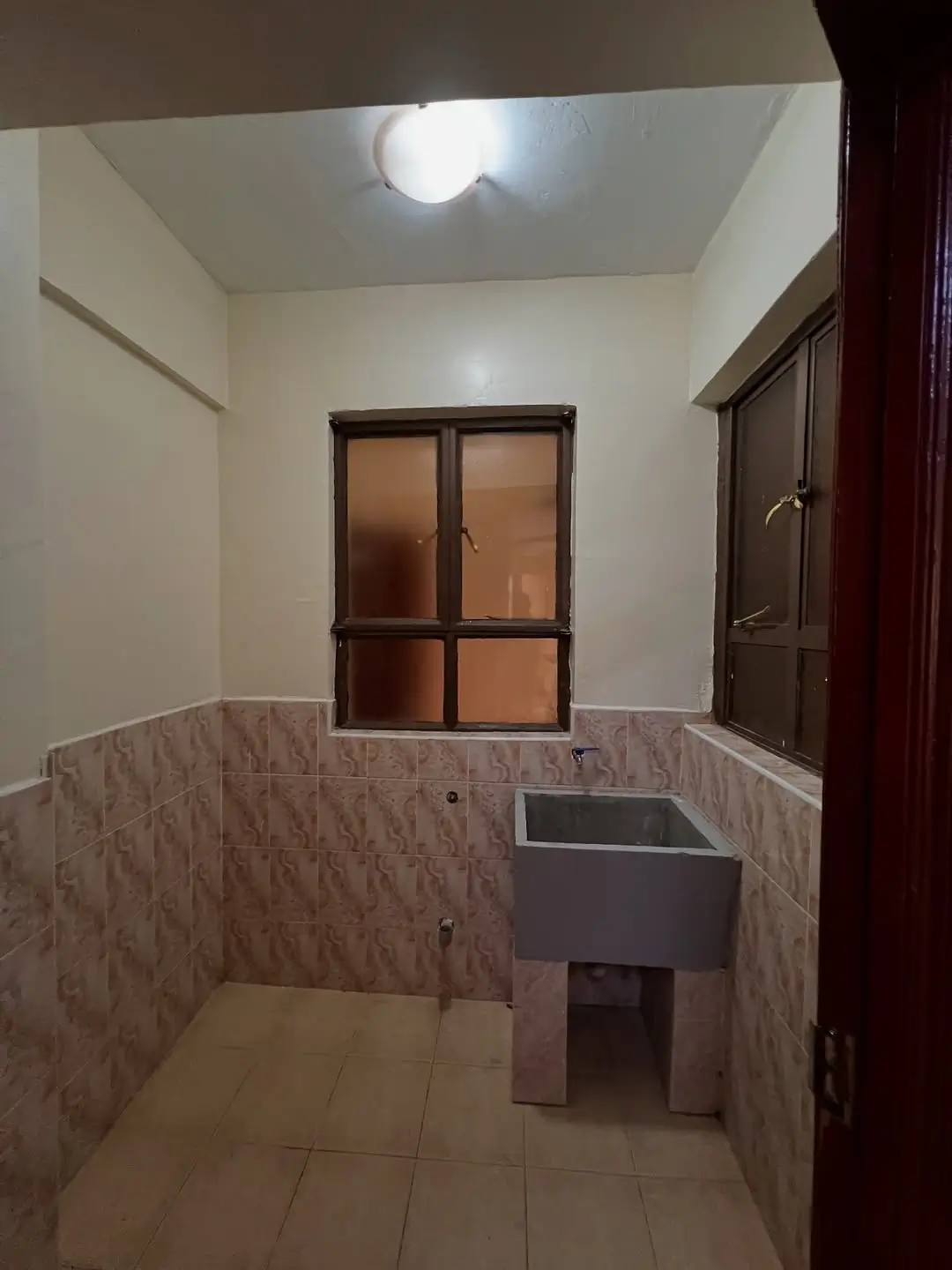 Compact bathroom with tile half-wall and pedestal sink