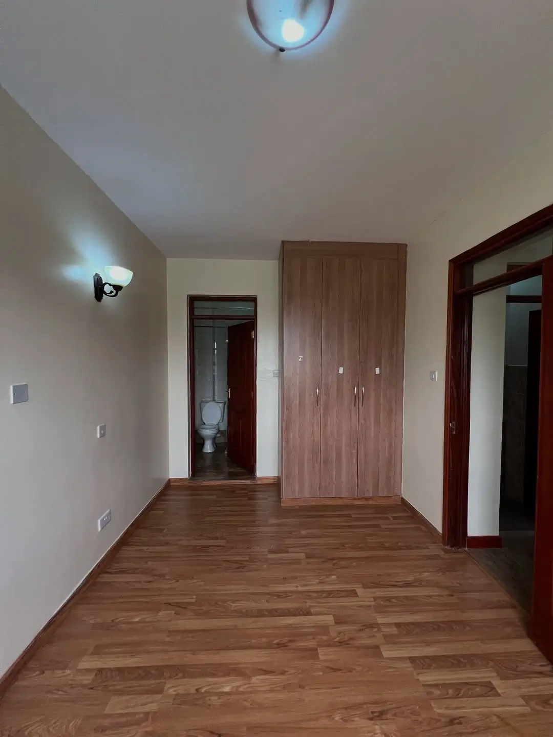 Corridor with wooden flooring, wall sconces, wardrobe access