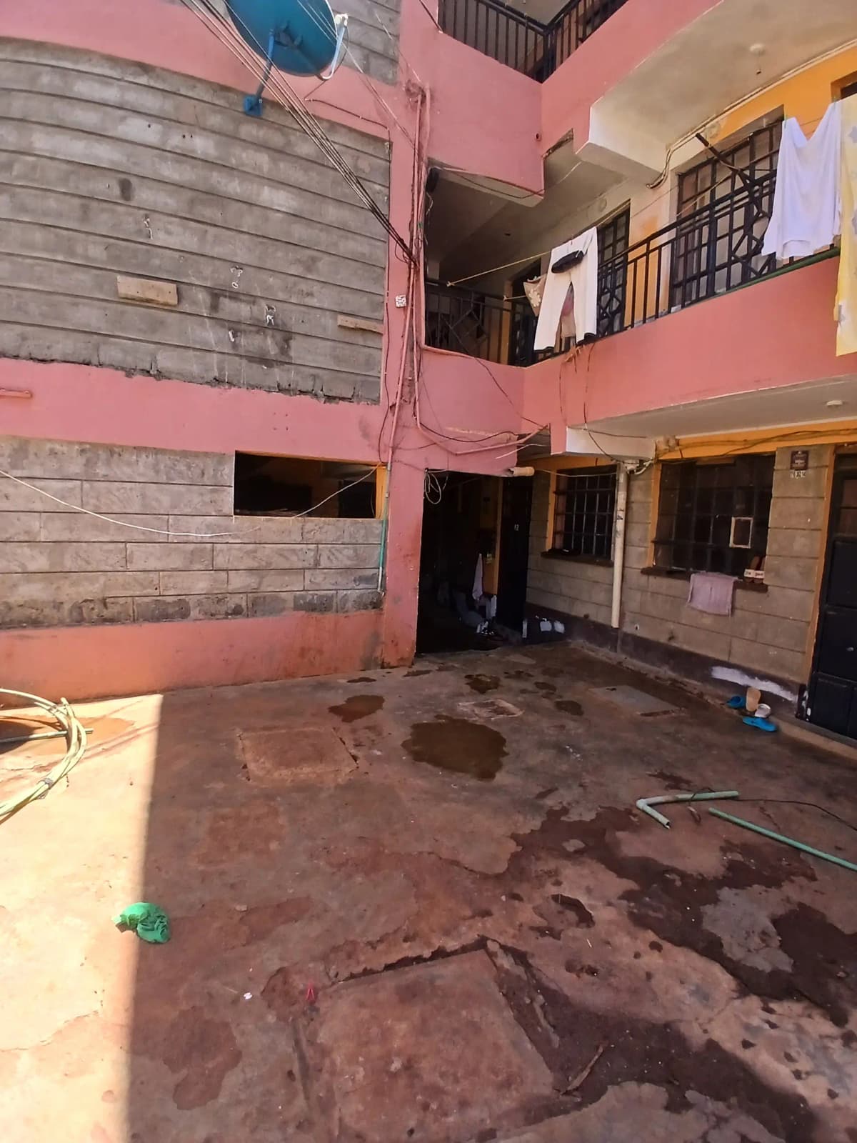 Compound courtyard with pink walls, under construction