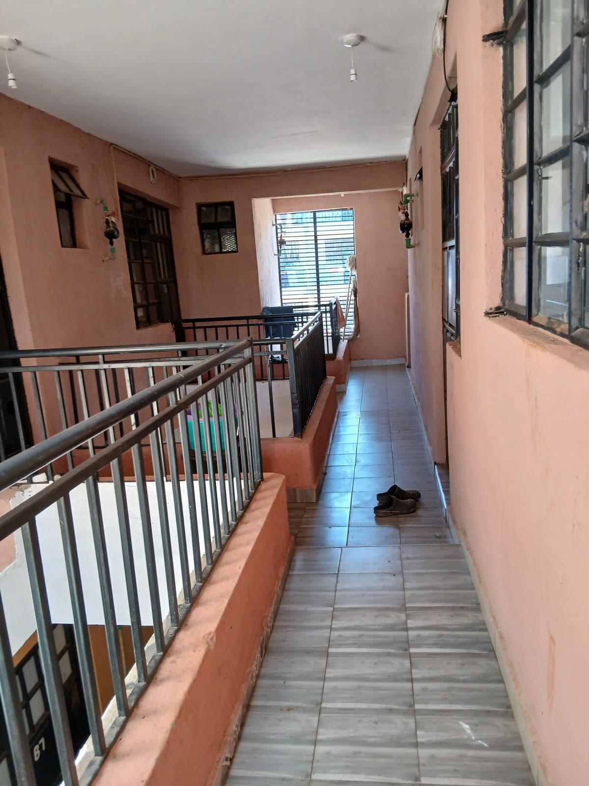 Interior corridor with metal railings and tiled flooring
