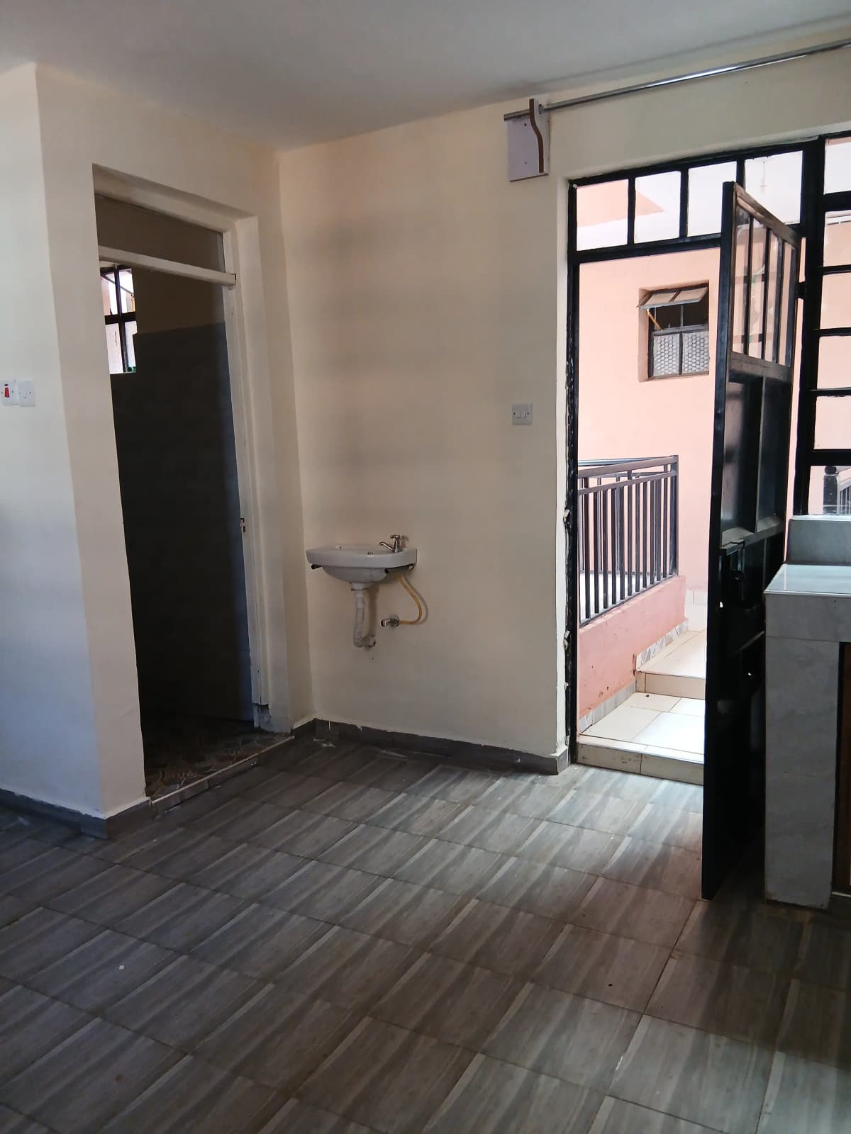 Bright corridor with dark tile flooring and open doorways