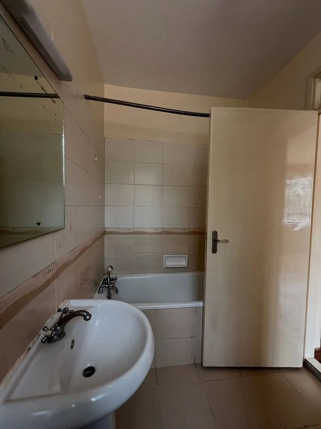 Compact bathroom with round sink and bathtub shower combo