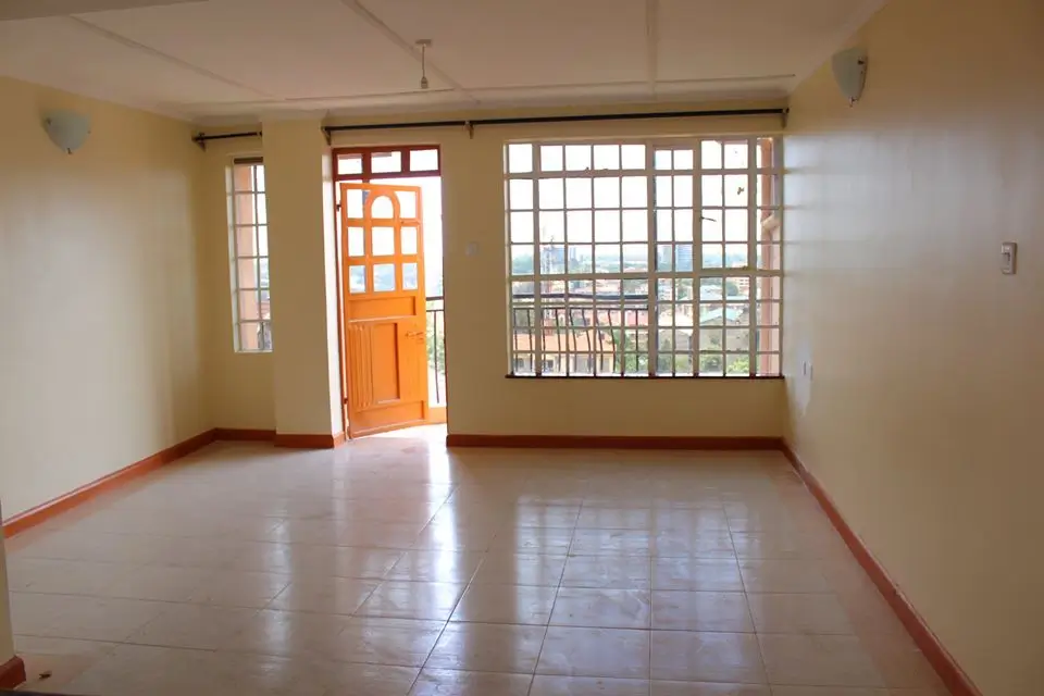 Spacious empty living room with polished tile floors, natural light