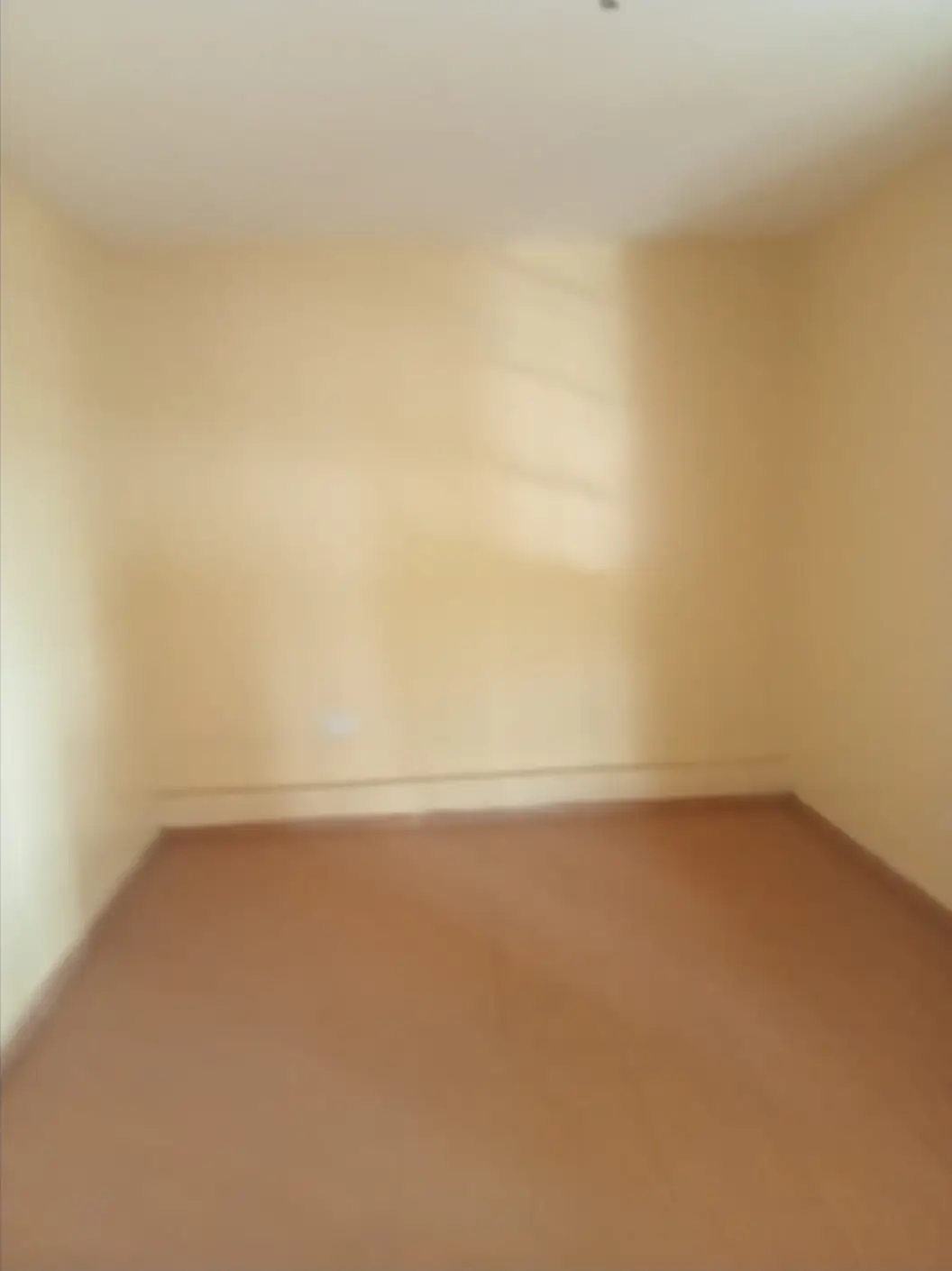 Empty bedroom with terracotta tile flooring and natural light