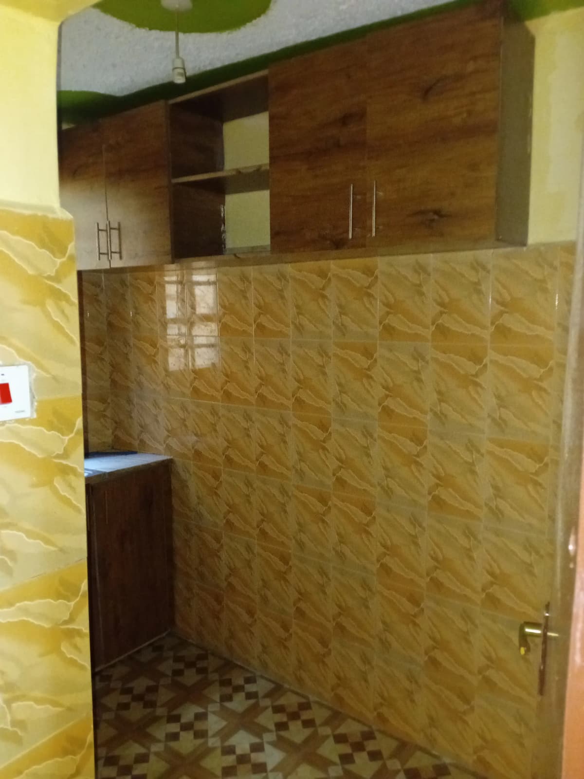 Bathroom with textured tile walls and wooden cabinetry