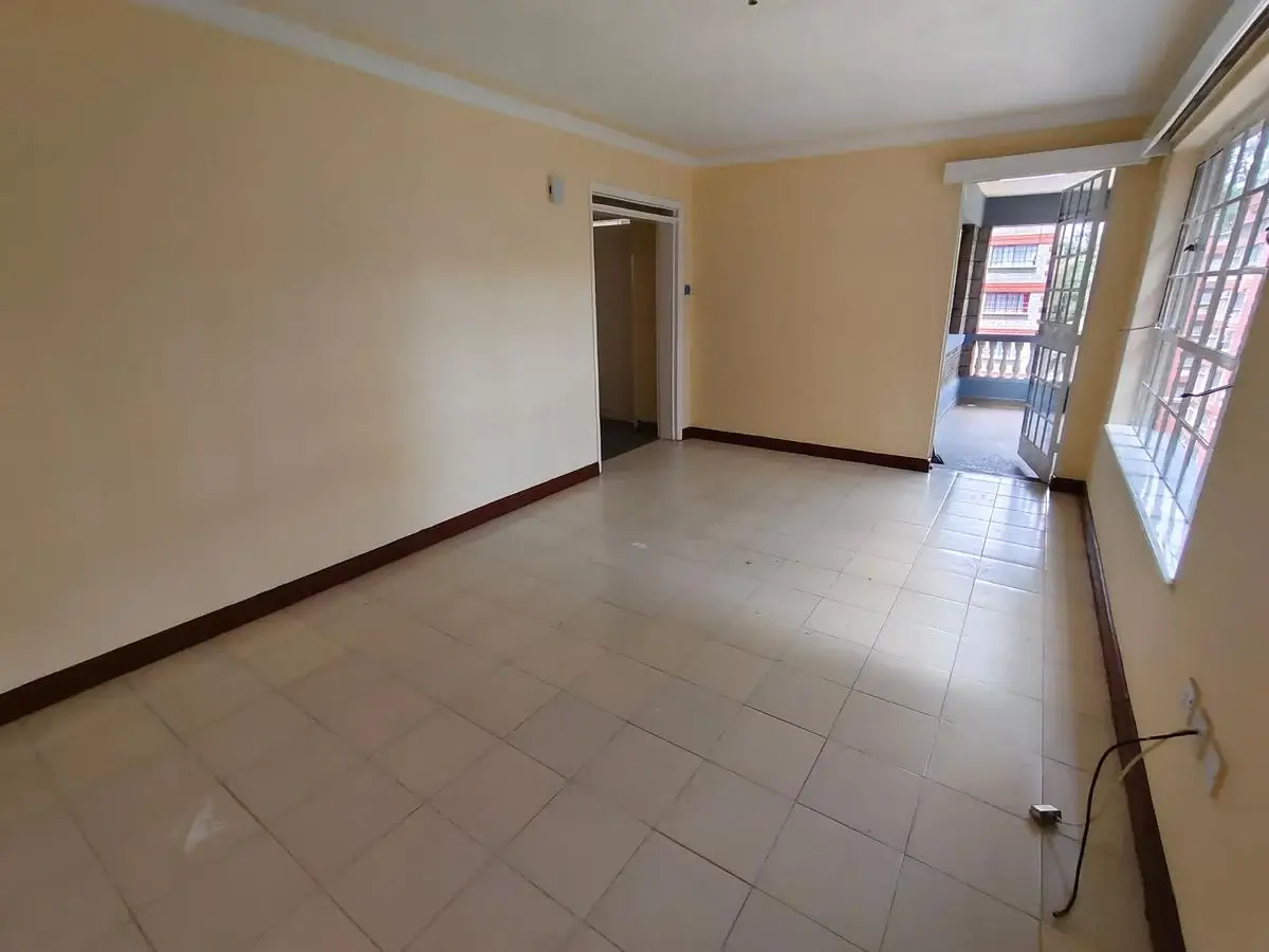 Spacious empty living room with tiled floors and natural light
