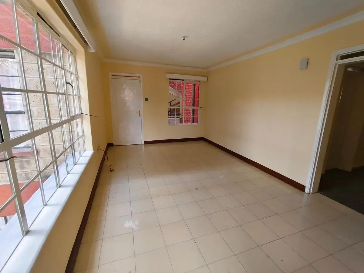 Spacious empty living room with yellow walls and tile flooring