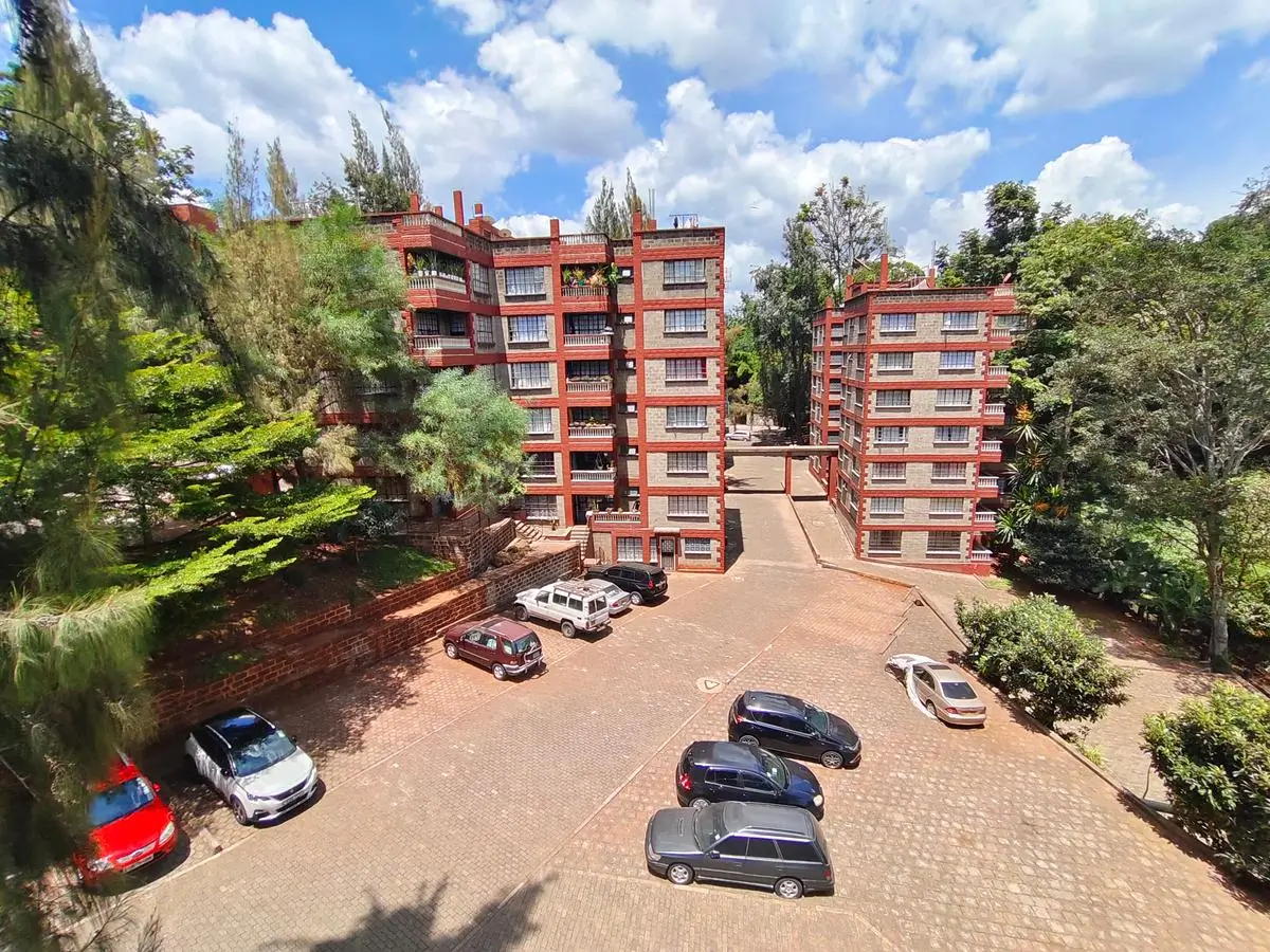 Red-brick apartment complex with shared parking compound and landscaping