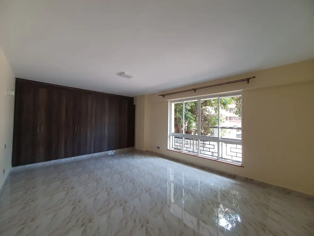 Spacious bedroom with large balcony access and built-in wardrobes