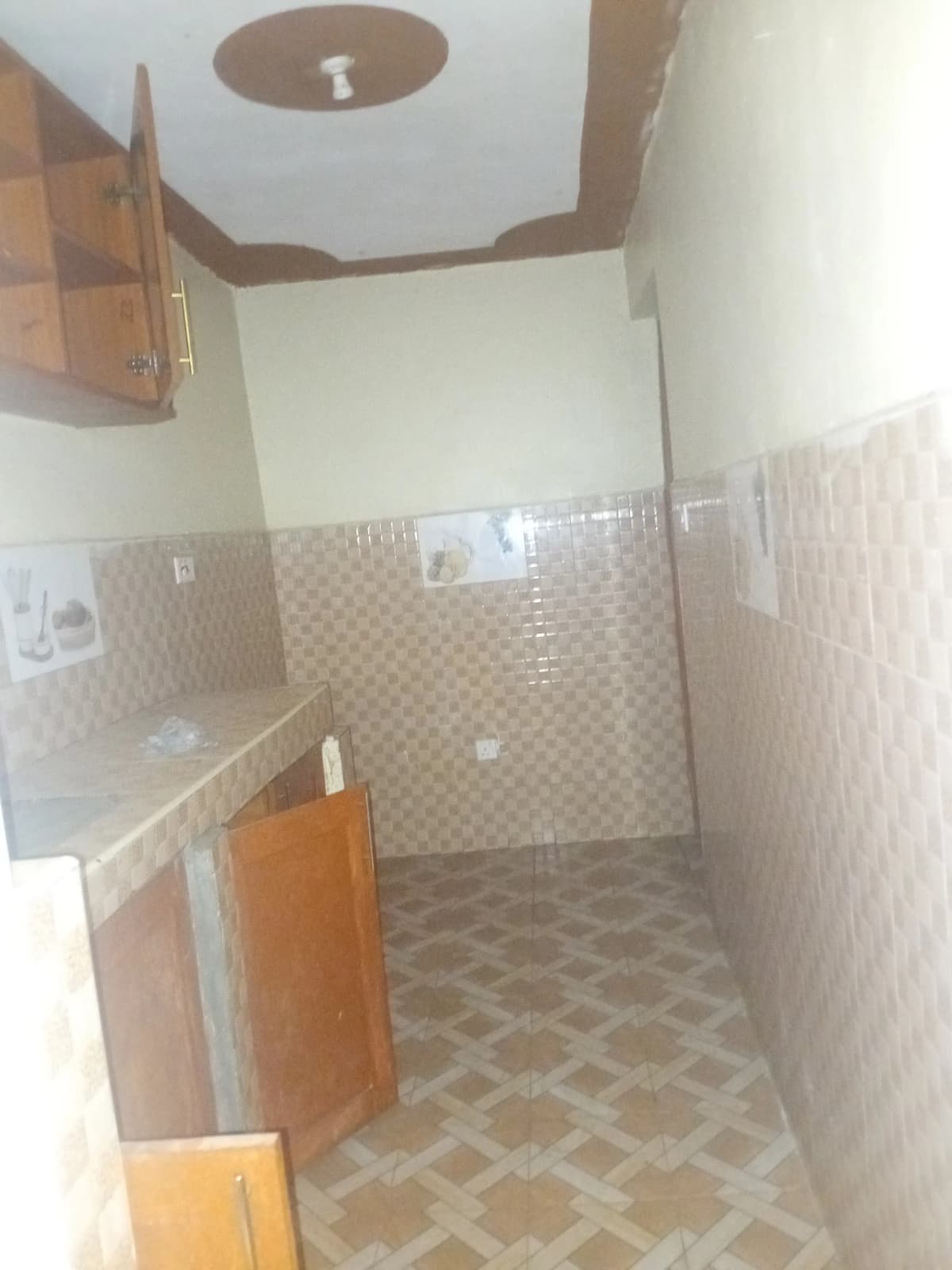 Compact bathroom with beige tiled walls and patterned floor