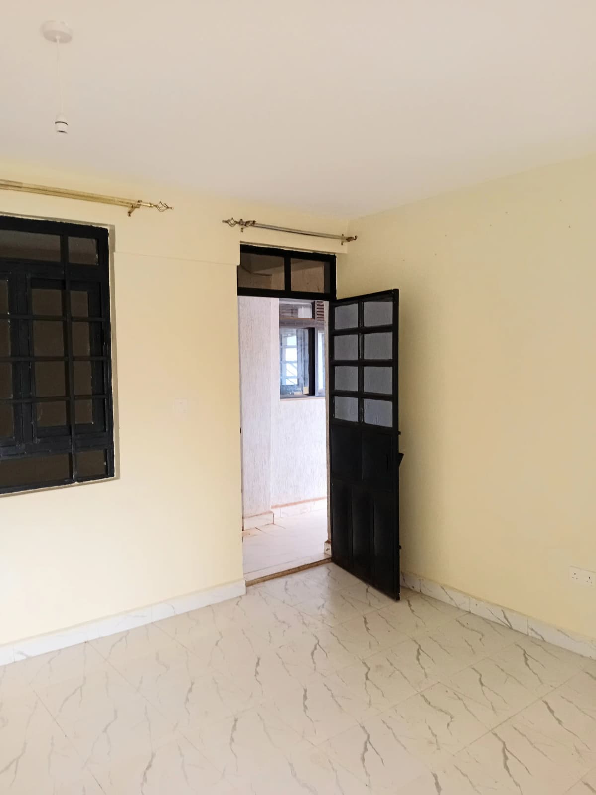 Empty living room with cream walls and black-framed doors