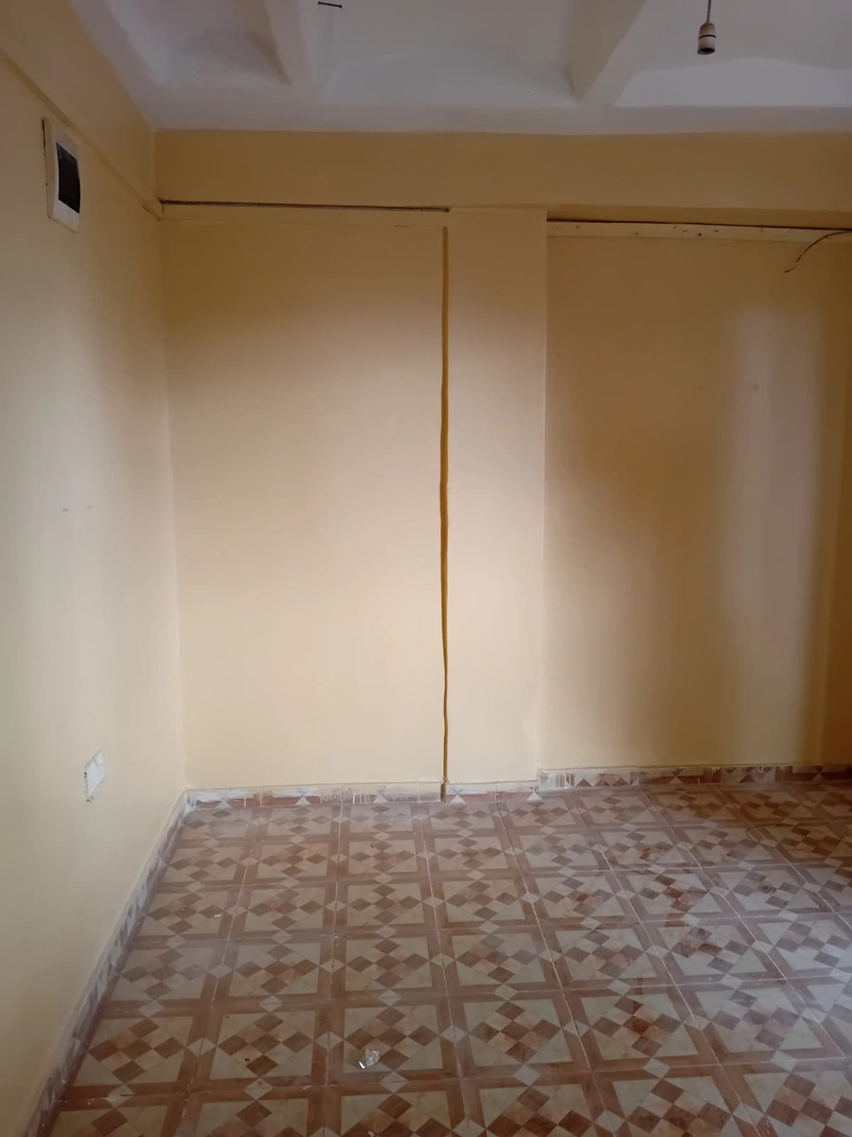 Unfurnished bedroom with geometric tile flooring and bare walls