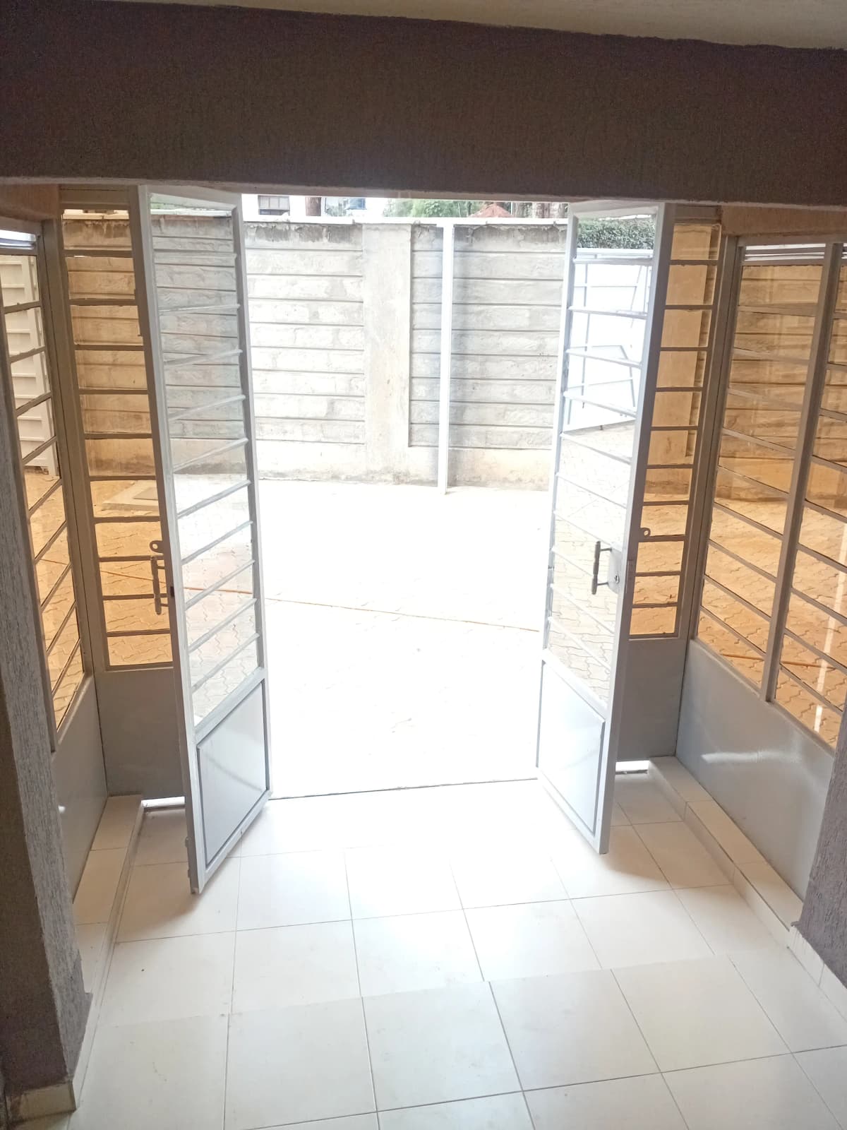 Covered balcony with louvered wooden doors and bright natural light