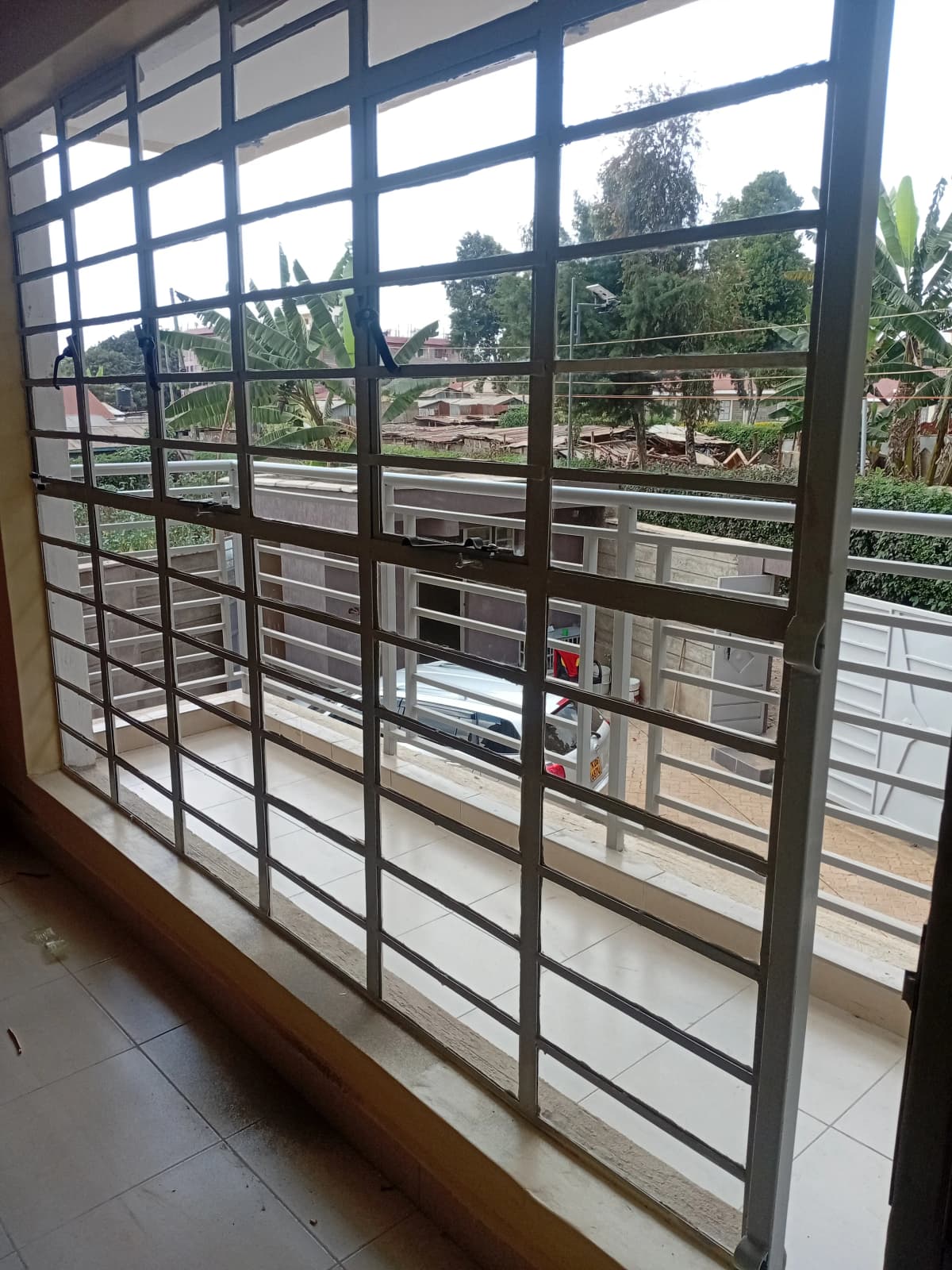 Interior view through barred windows overlooking compound grounds