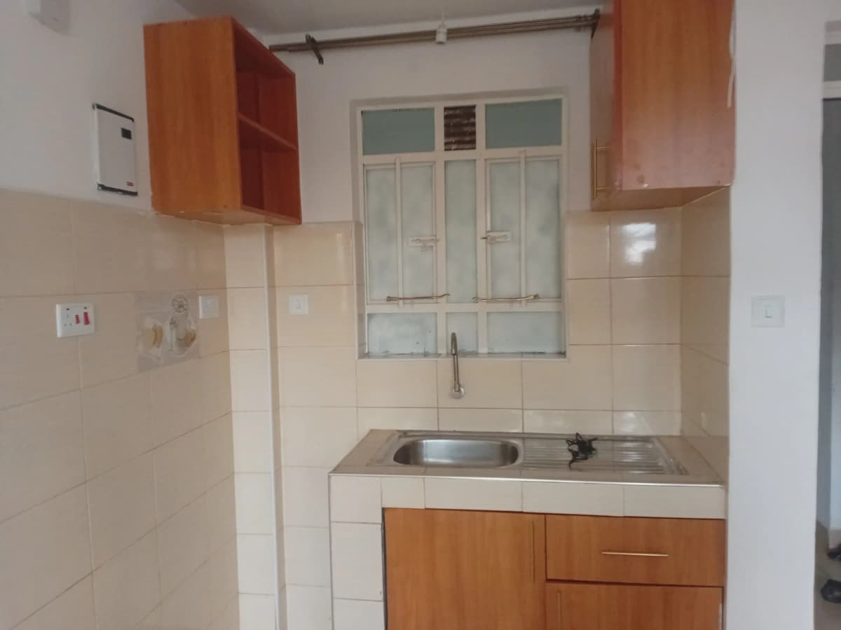 Compact kitchen with wooden cabinets and stainless steel sink