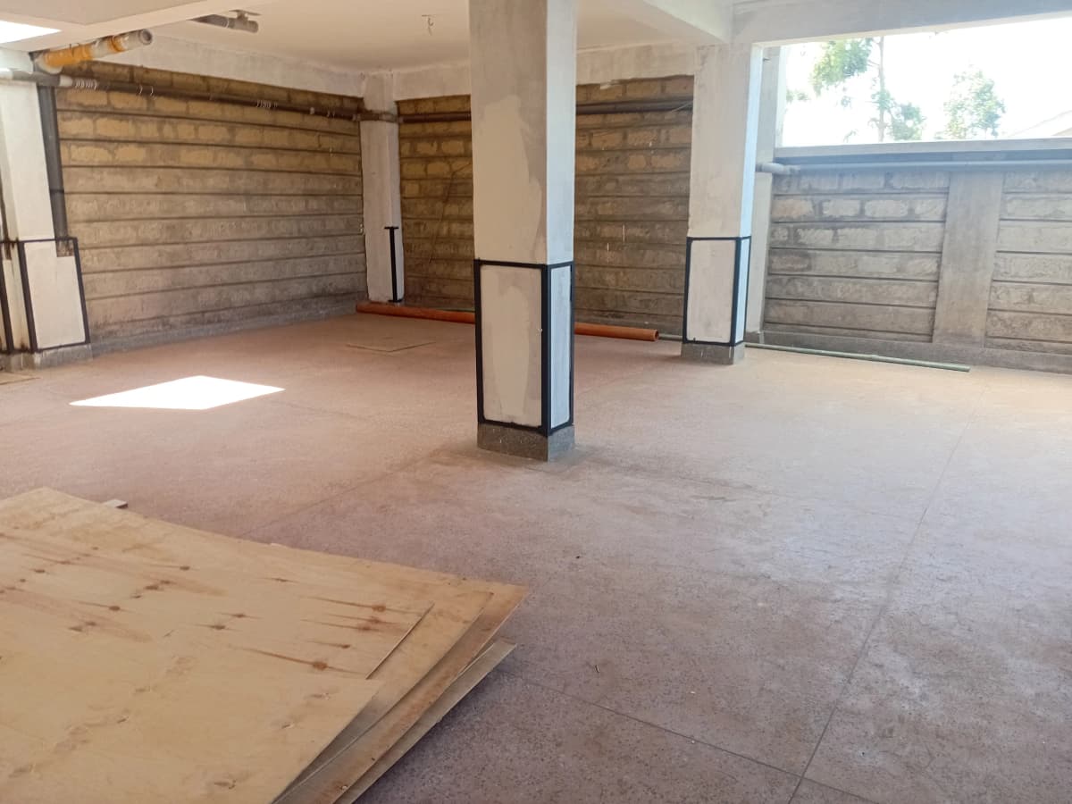 Large empty garage space with brick walls and overhead doors