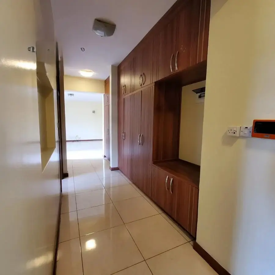 Hallway with built-in wooden storage cabinets and tiled flooring