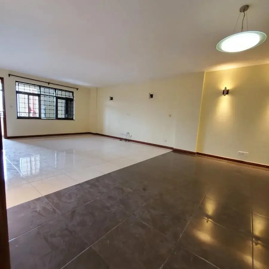 Spacious living room with polished floors and natural light