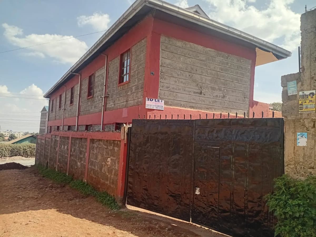 Red and stone two-story residential building with metal gate