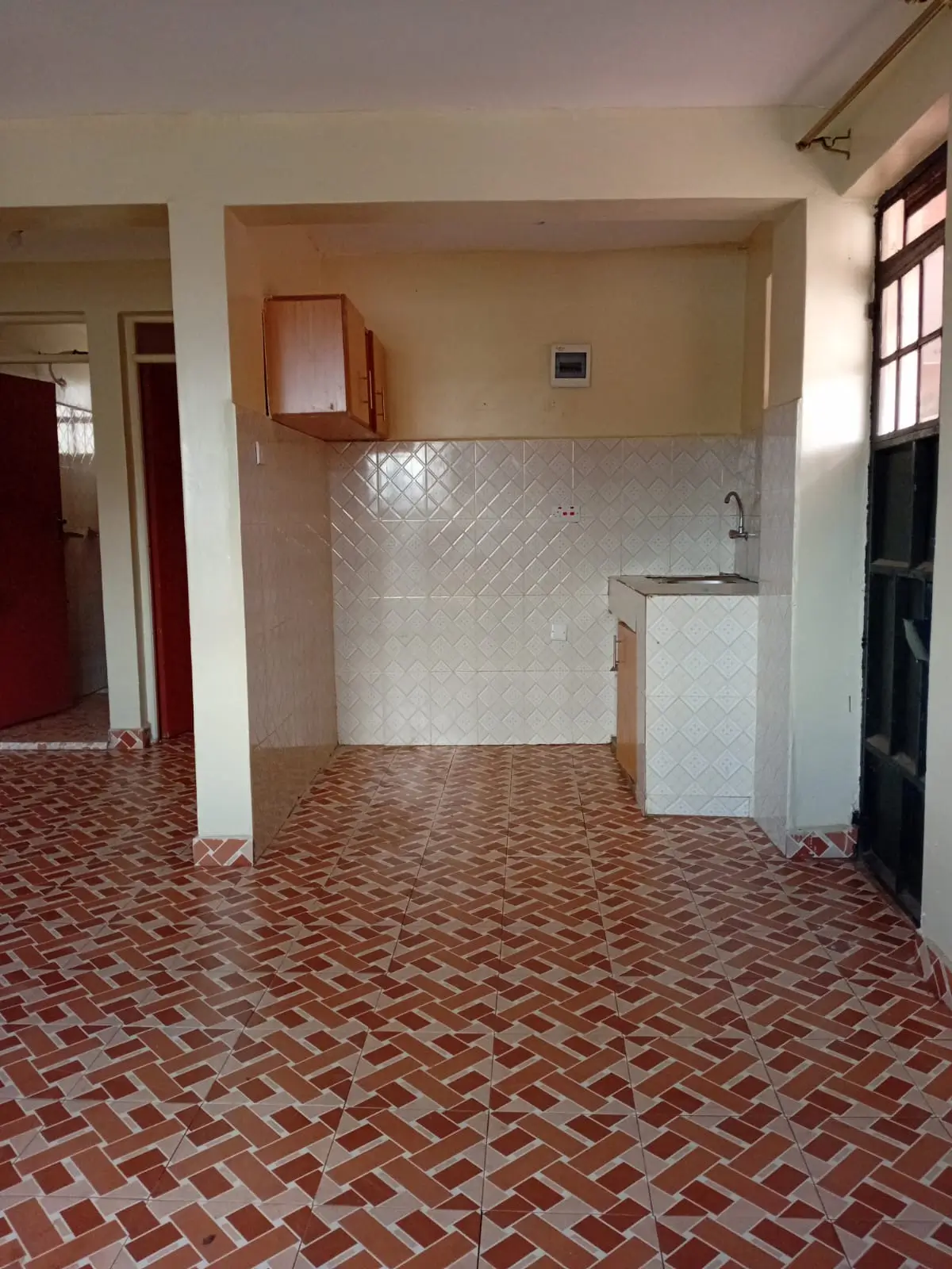 Compact kitchen with white tile backsplash and herringbone floor