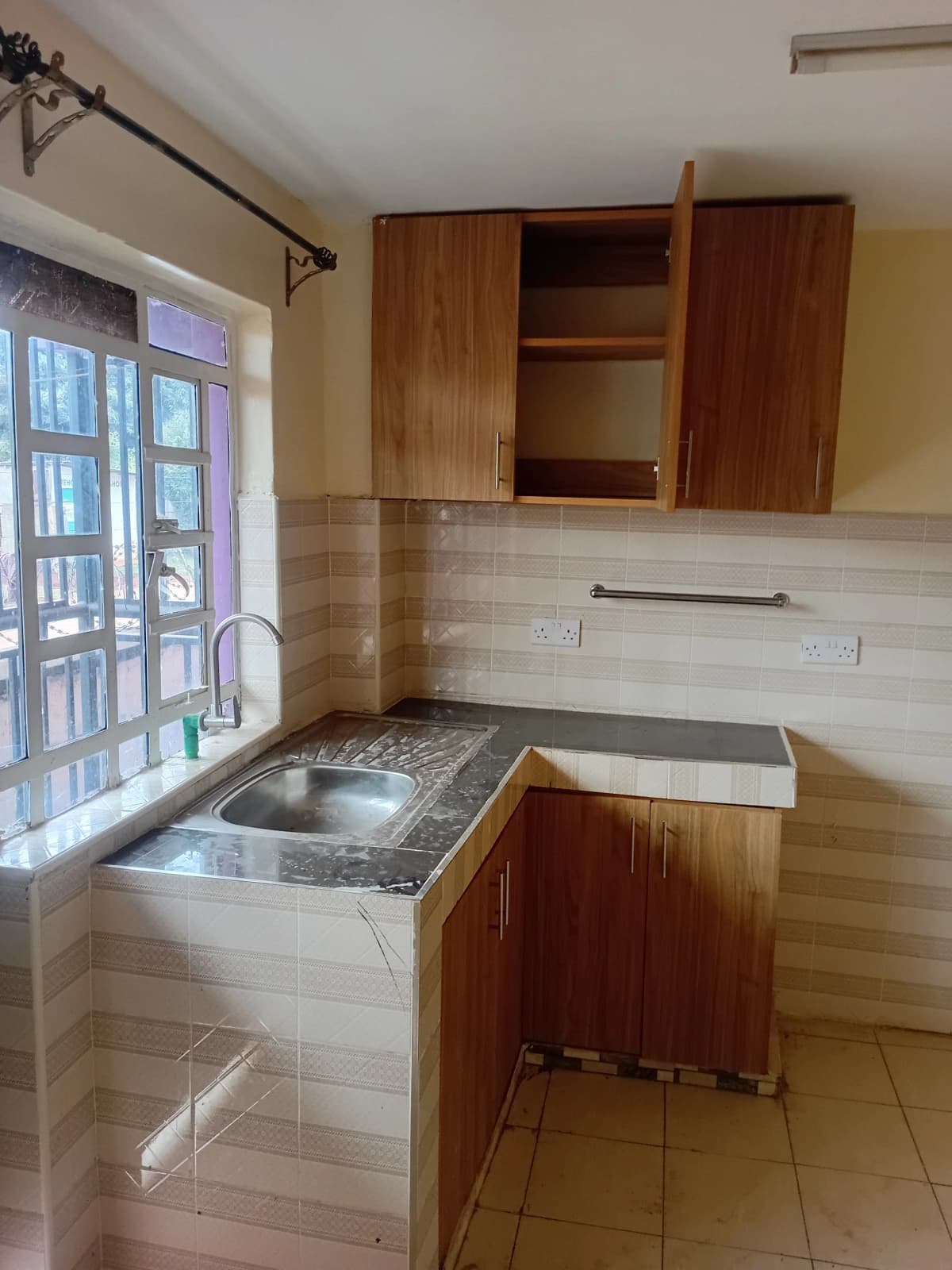 Compact kitchen with wooden cabinets and tiled backsplash