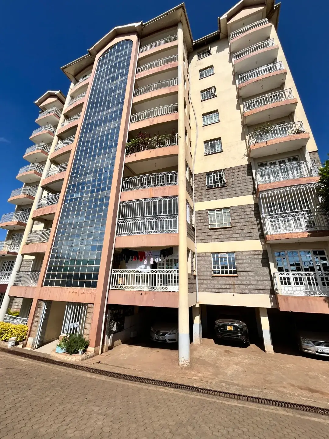 Multi-story residential building with ground-floor parking bays