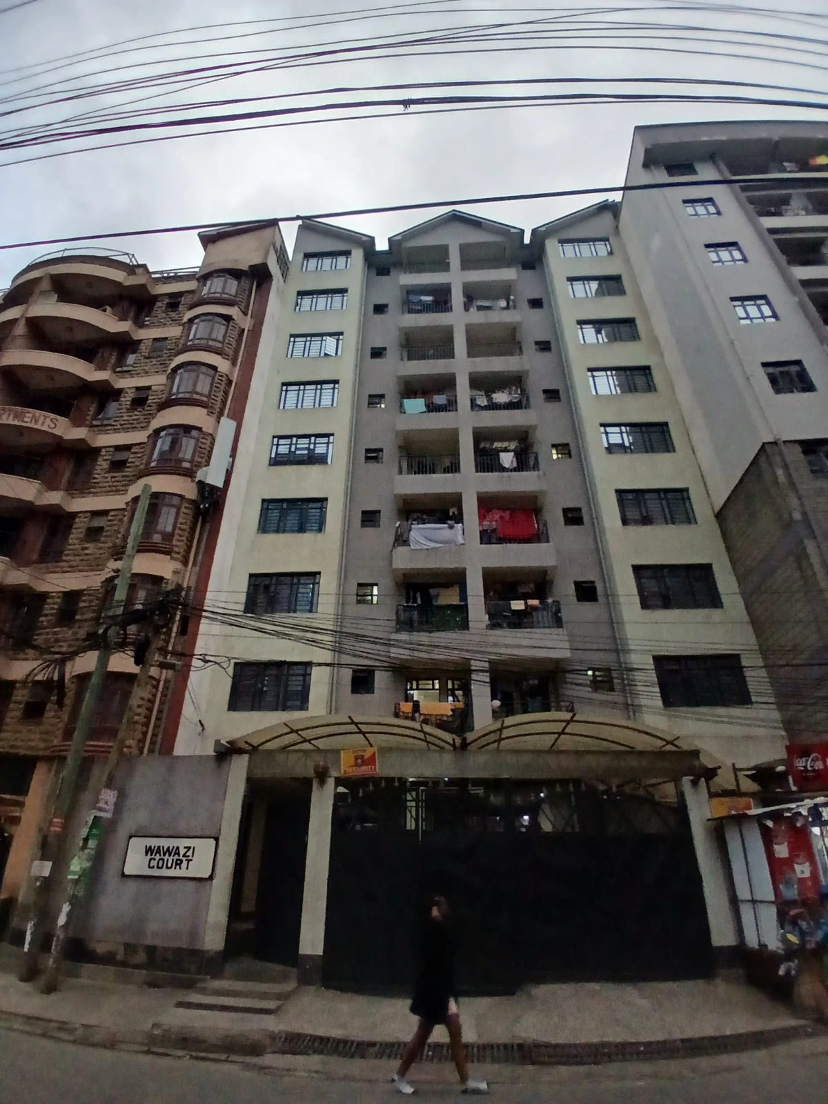 Multi-story residential building facade with ground-floor parking entrance