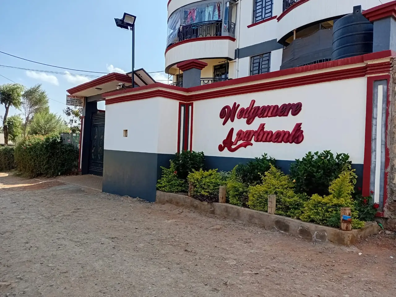 Building entrance with red and white facade, landscaped grounds