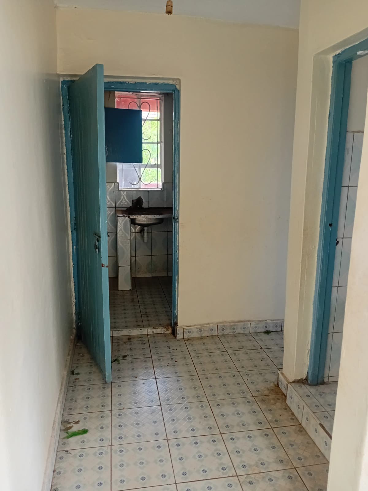 Building corridor with teal doors and tiled flooring