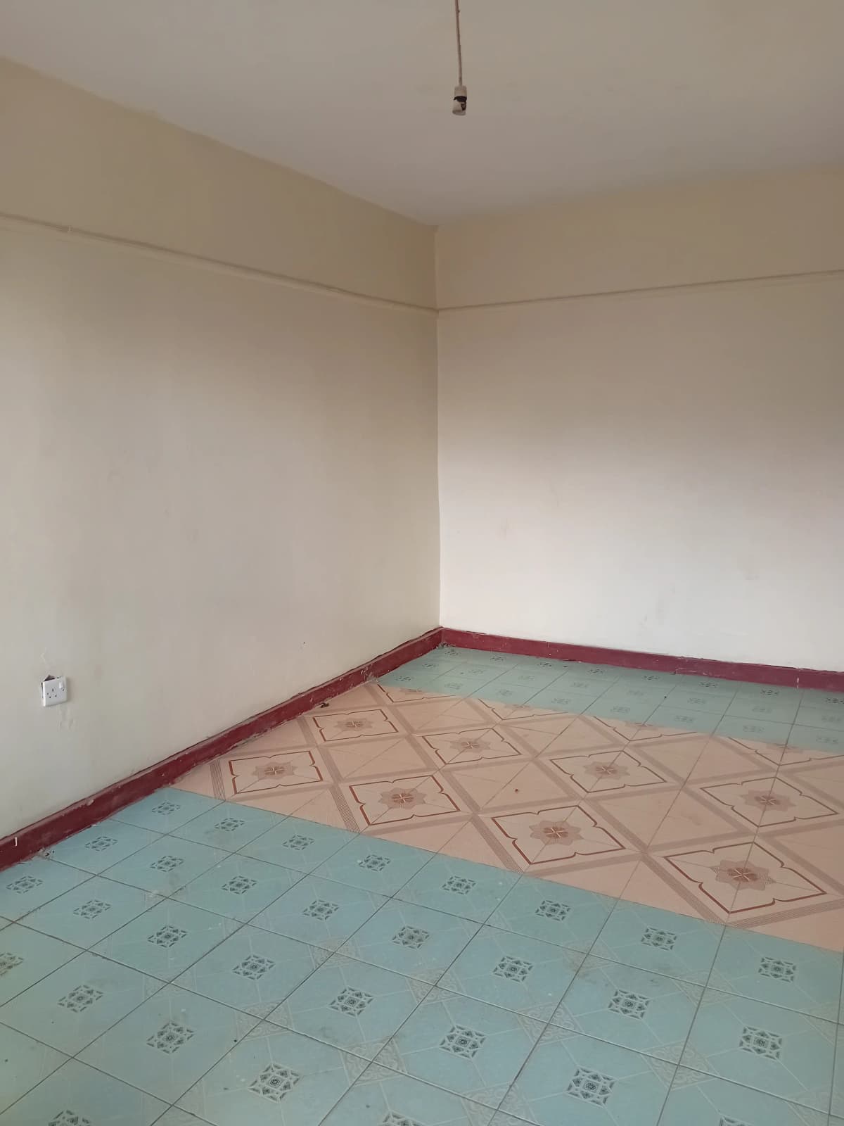 Empty bedroom with patterned tile flooring and cream walls