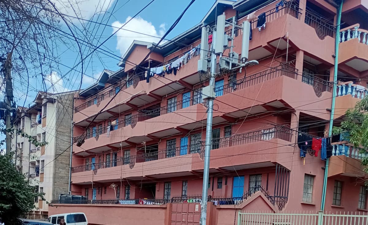 Multi-story residential building with pink facade and balconies