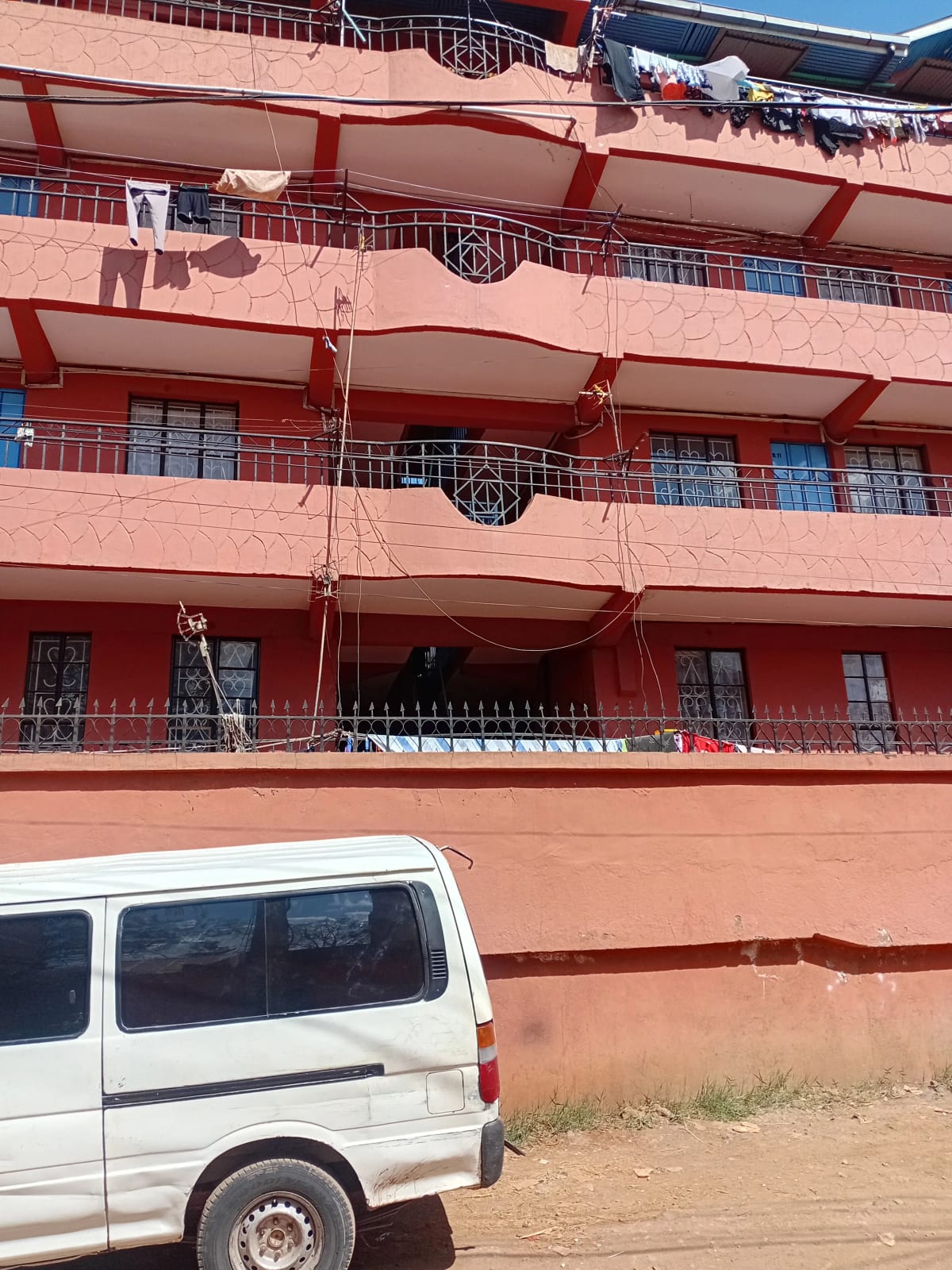 Red multi-story residential building facade with balconies
