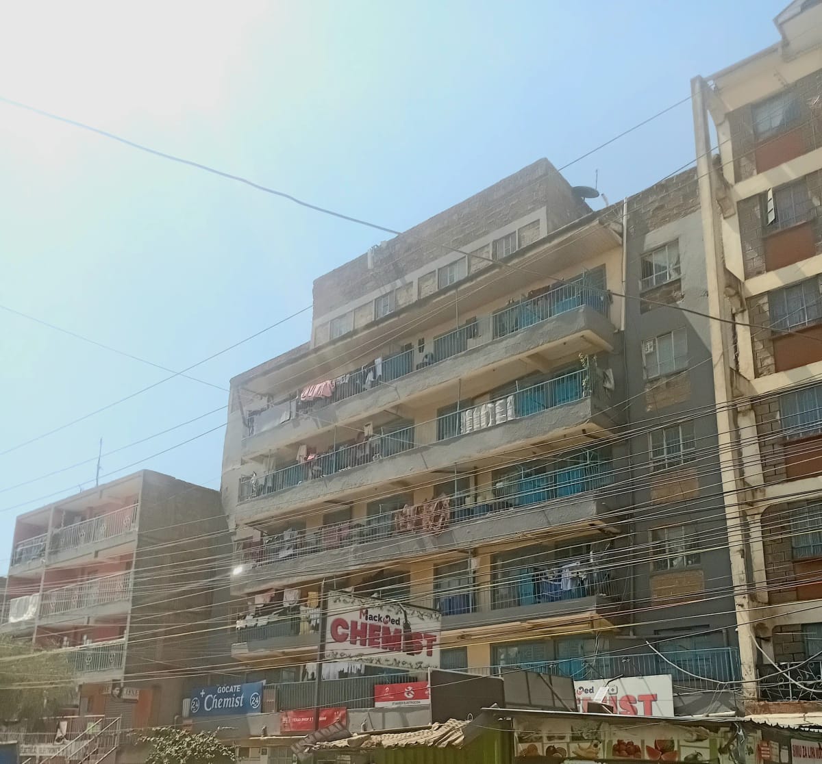 Multi-story residential building facade with balconies and ground-floor shops