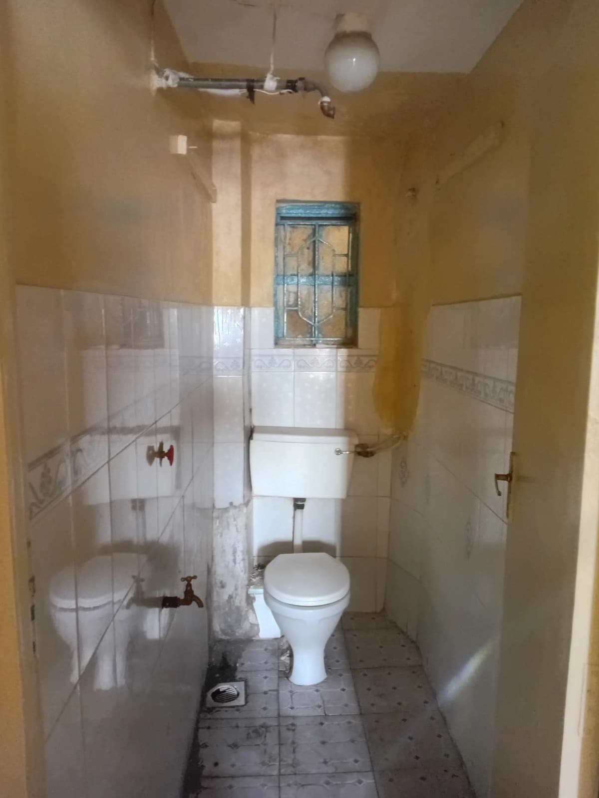 Compact bathroom with toilet, sink, and shower enclosure