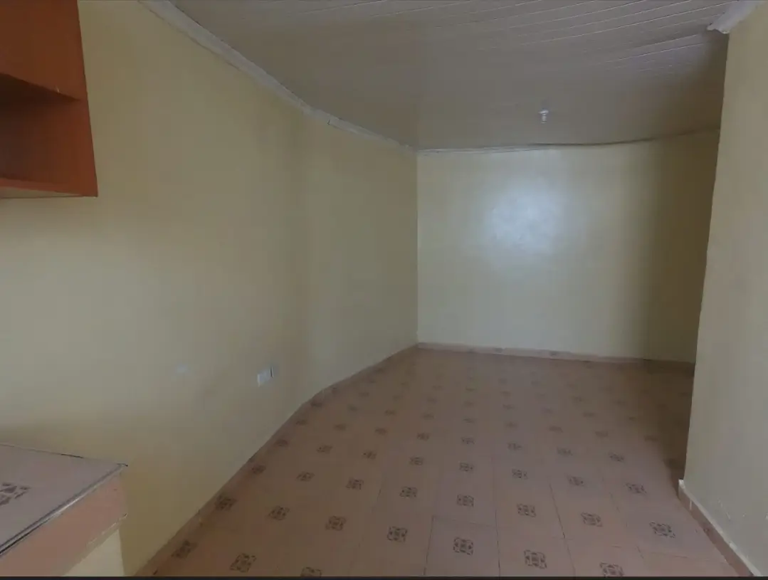 Empty bedroom with patterned carpet and natural light