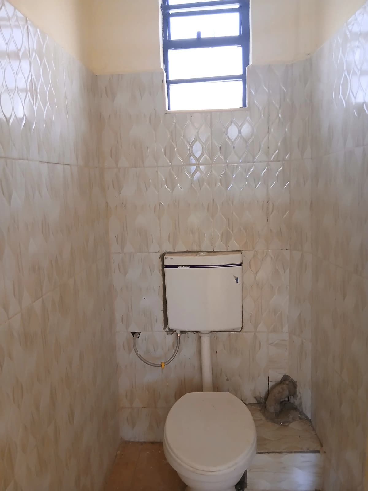 Toilet cubicle with ceramic tiles and high window