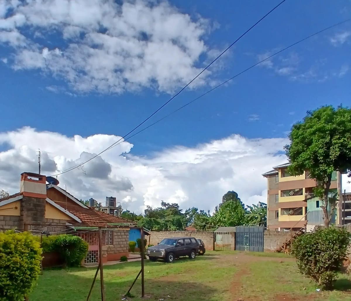 Residential compound with parked vehicle and green grounds