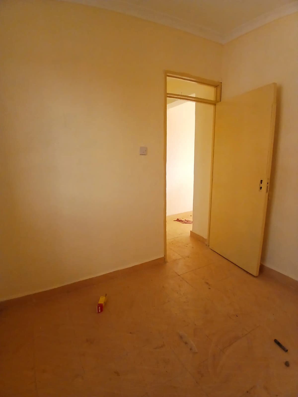 Empty bedroom with yellow walls and wooden flooring