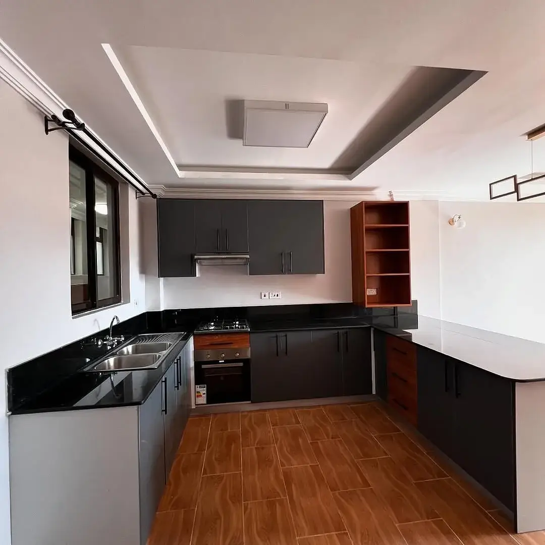 Modern kitchen with black cabinetry, wood flooring, stainless steel sink