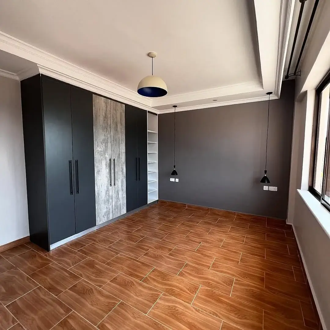 Spacious bedroom with built-in wardrobes and herringbone flooring
