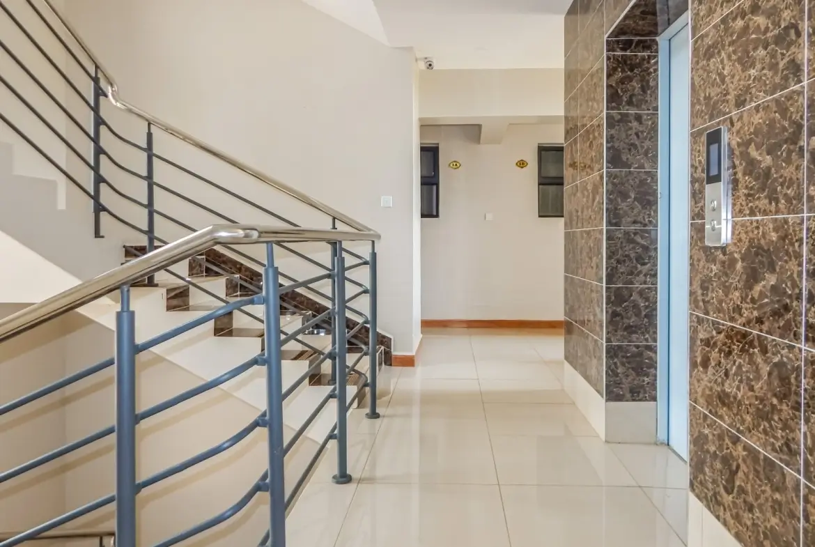 Modern building lobby with metal staircase and marble wall paneling