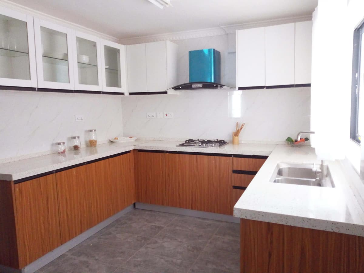 L-shaped kitchen with wood cabinetry and white countertops