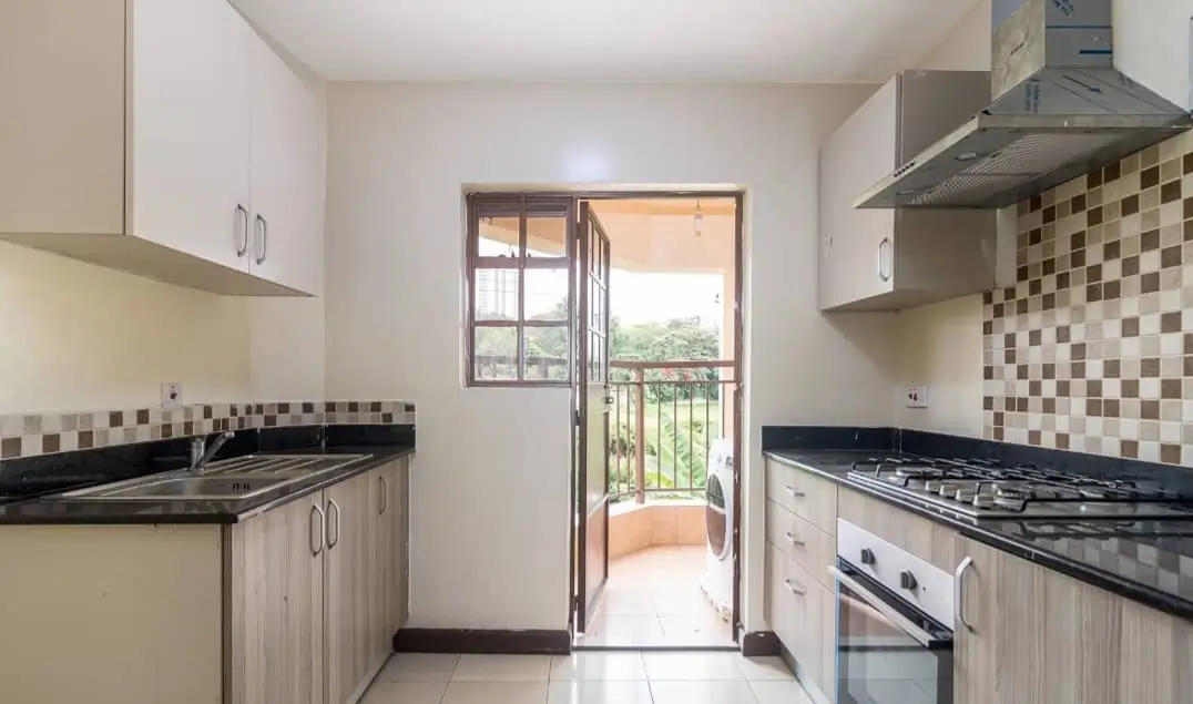 Modern kitchen with black countertops, mosaic backsplash, balcony view