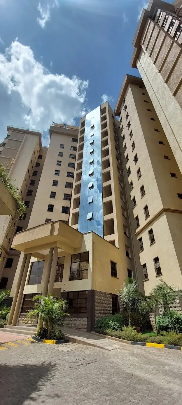 Multi-story residential building facade with landscaped compound entrance