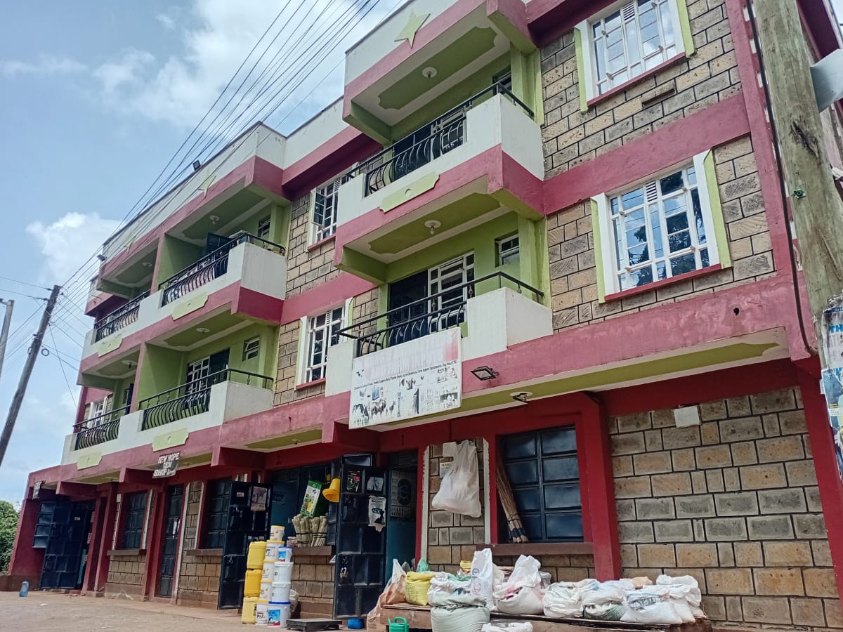 Multi-story residential building with pink and green facade