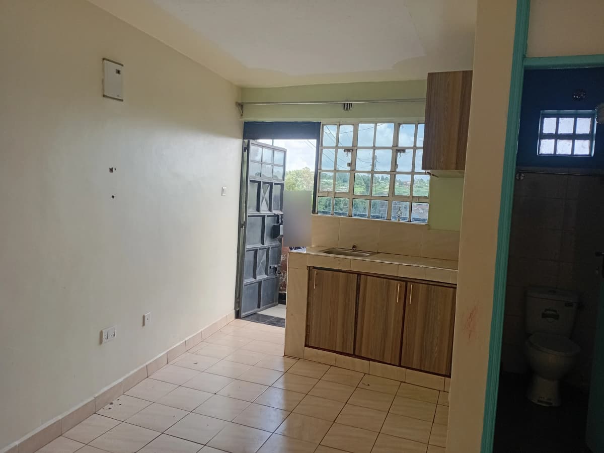 Compact kitchen with wooden cabinets and large window access