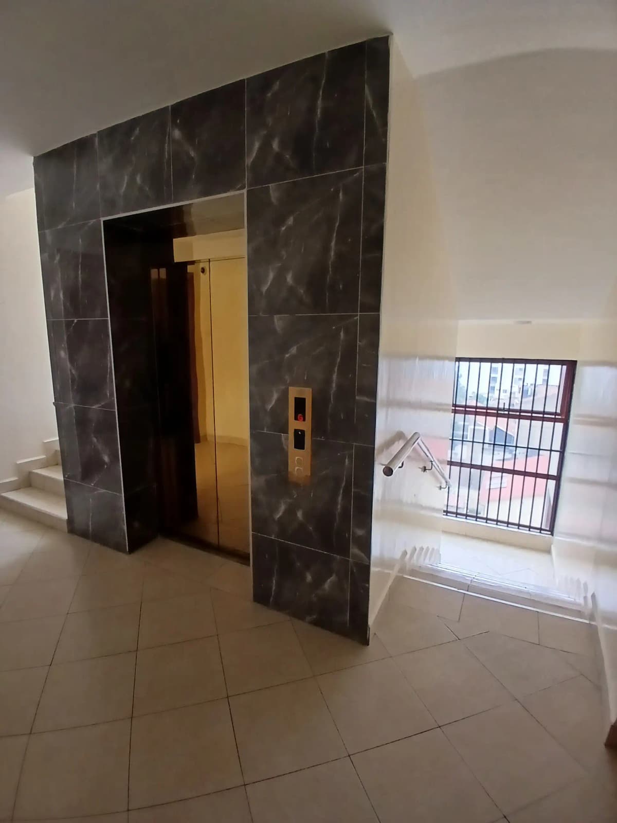Building lobby with elevator and marble-clad entrance doors