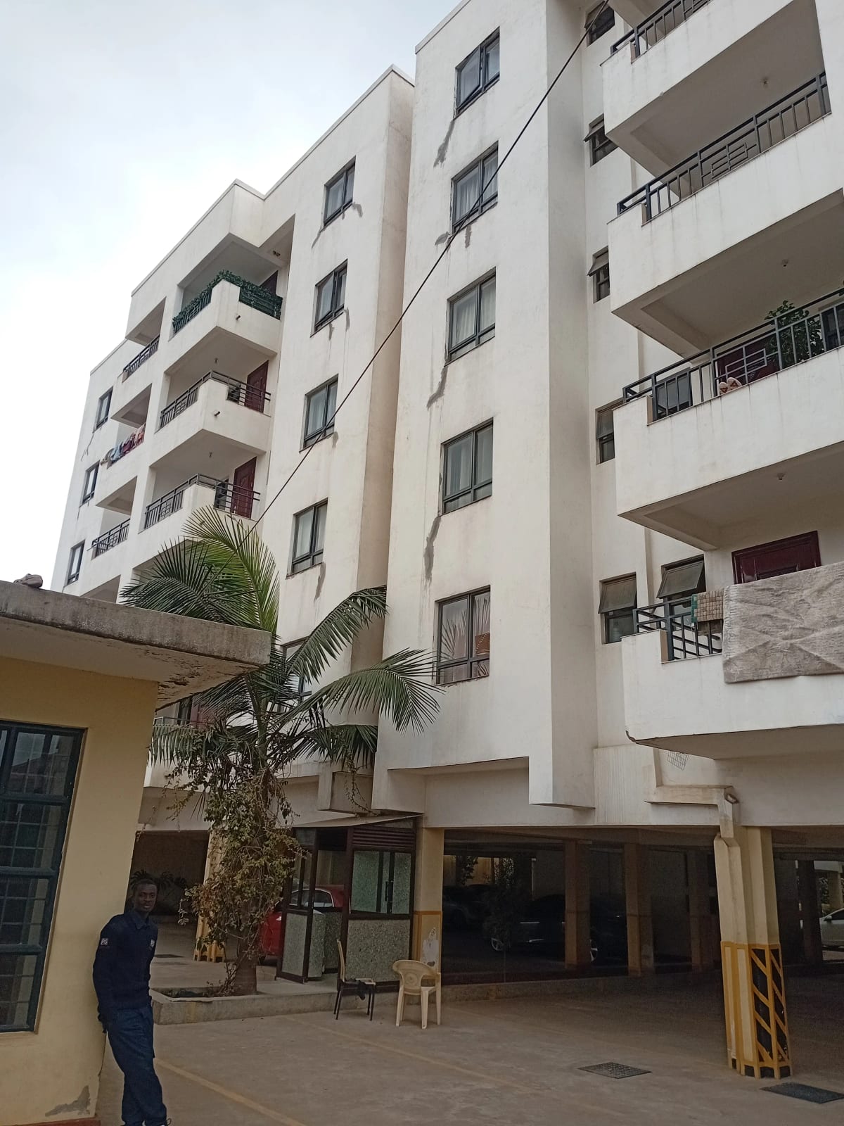 Modern multi-story residential building with balconies and ground level entry