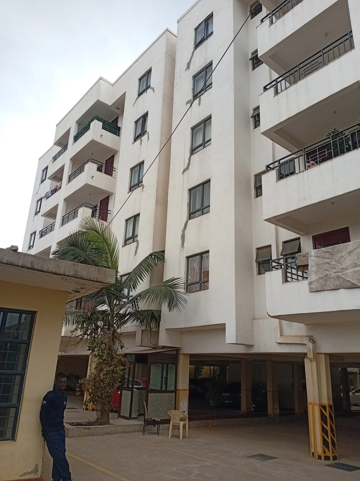 Modern multi-story residential building with balconies and ground level entry