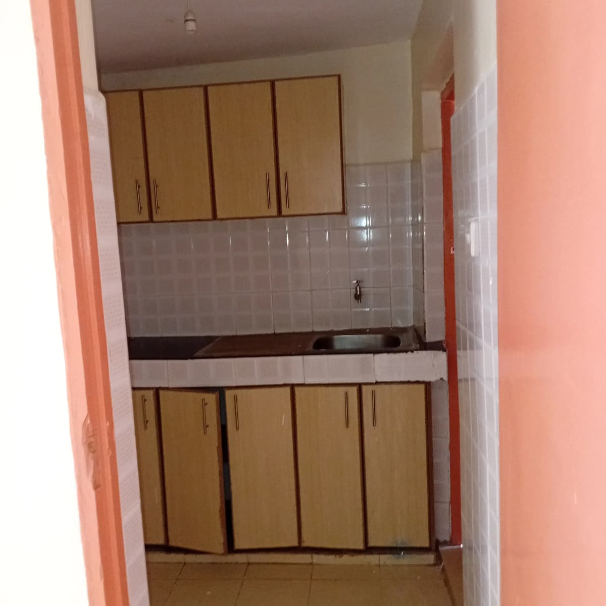 Compact kitchen with wooden cabinets and tiled backsplash